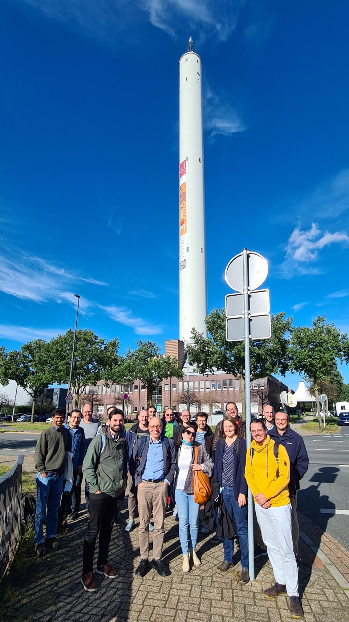 Part of the Research Unit FOR 2688 in front of the 146 m high Bremen drop tower on the site of the University of Bremen.